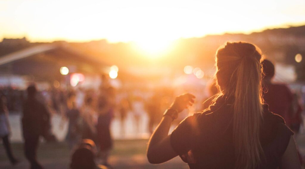 A post-secondary student thinking about alcohol use at a sunny outdoor event